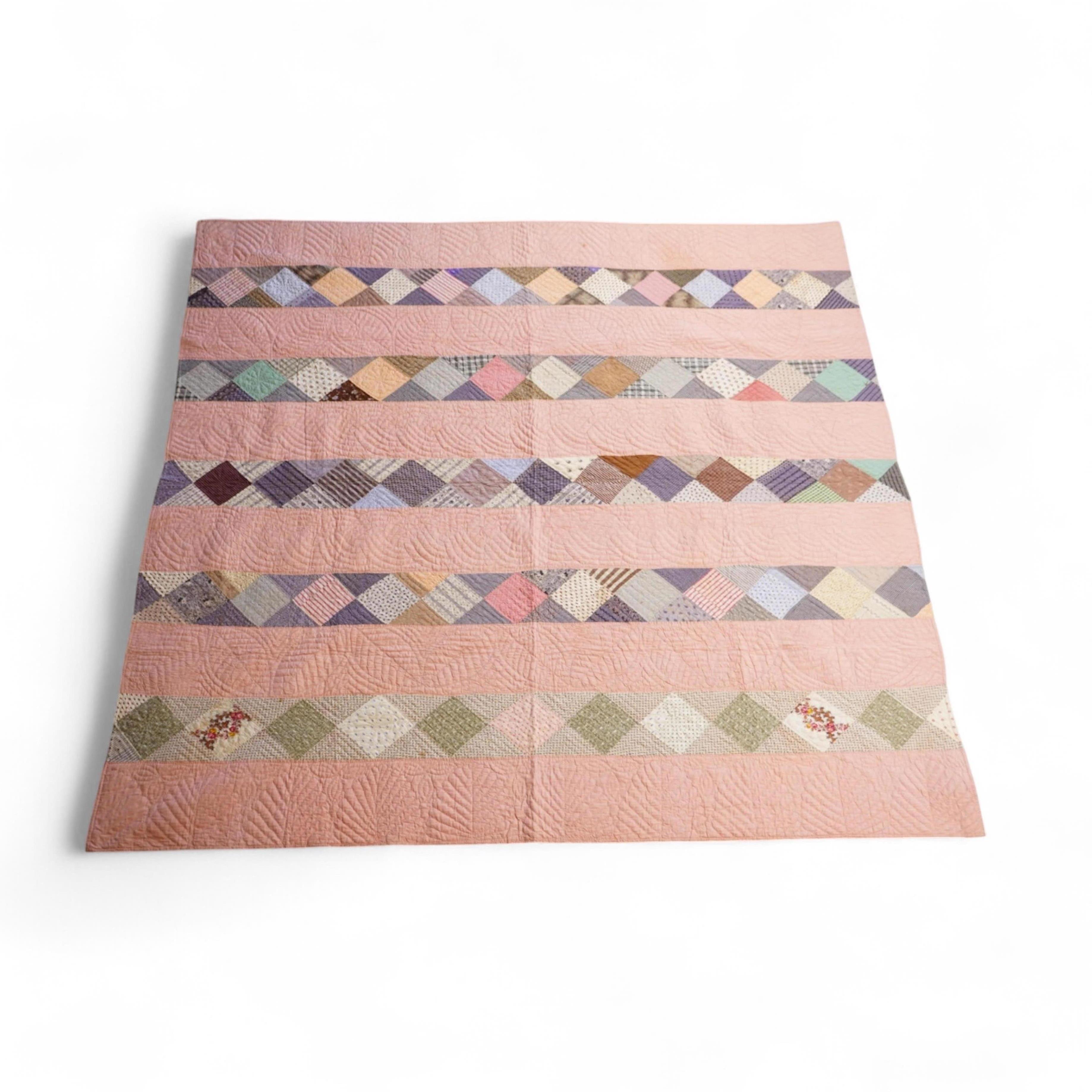 A late 19th century English, possibly ‘North Country’ cotton, hand quilted bed cover. Worked in stripes, with alternate patch worked stripes of differing colour fabrics. Made from fashionable cotton fabrics of the era. R